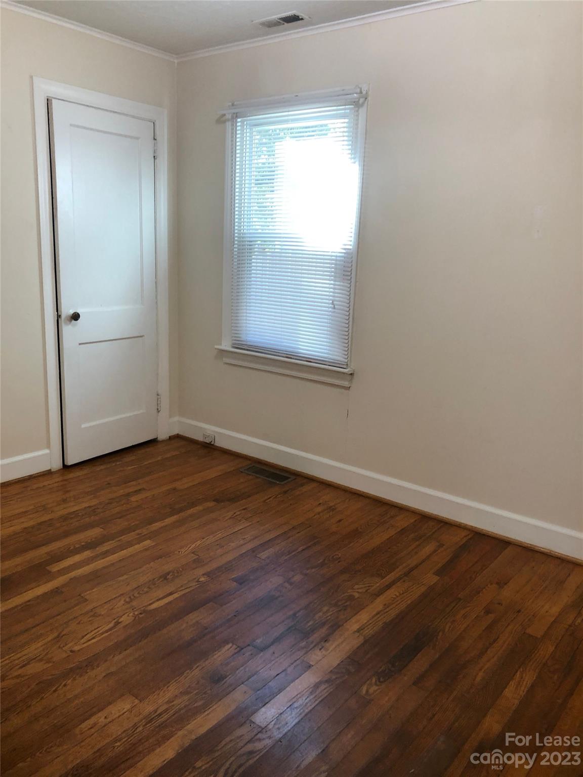 3200 Sam Wilson Road Charlotte, NC 28214 - Photo 11 of 13 an empty room with wooden floor and windows
