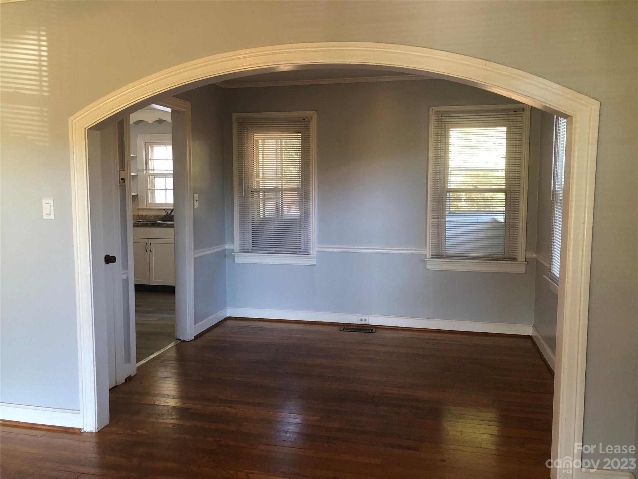 3200 Sam Wilson Road Charlotte, NC 28214 - Photo 4 of 13 an empty room with wooden floor and windows