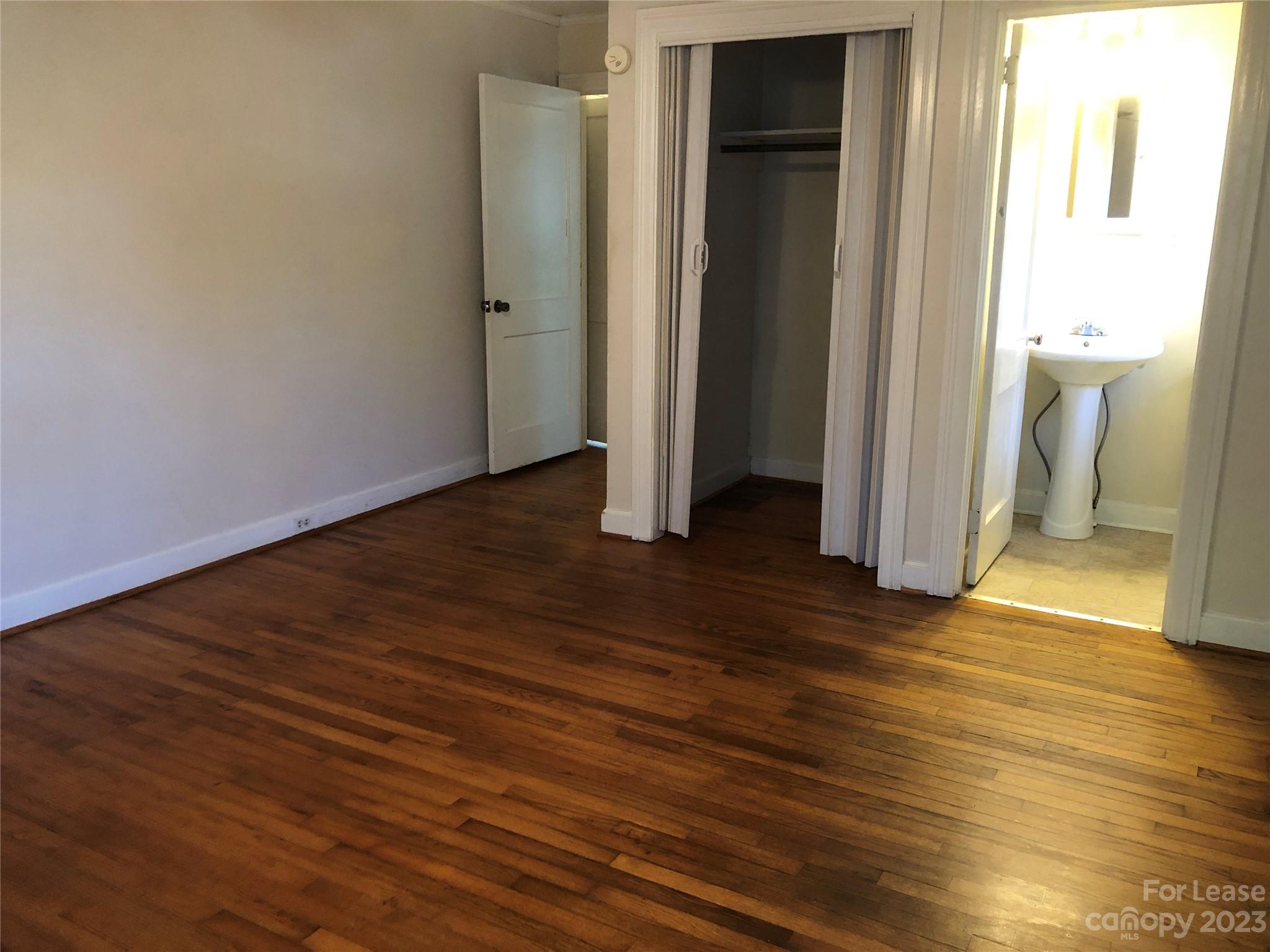 3200 Sam Wilson Road Charlotte, NC 28214 - Photo 7 of 13 an empty room with wooden floor and a window