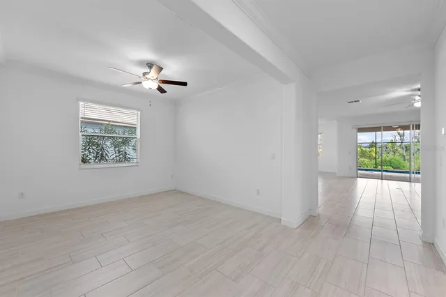 an empty room with windows and ceiling fan