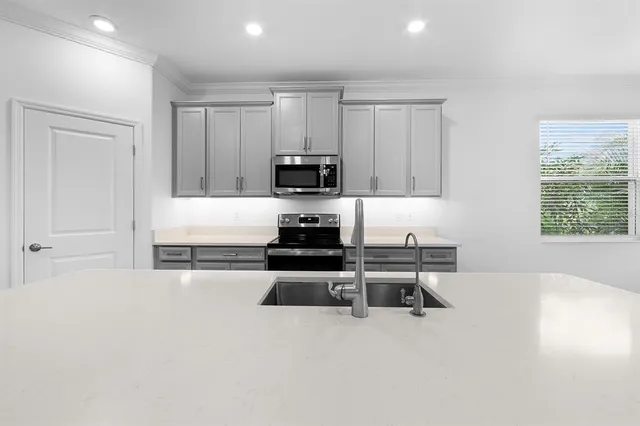 a view of a kitchen with white cabinets and a refrigerator