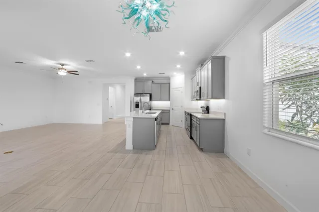 a view of an empty room with kitchen view and a window