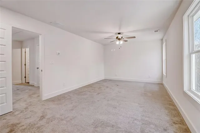 an empty room with fan and windows