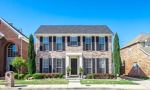 a view of a brick house with yard and plants
