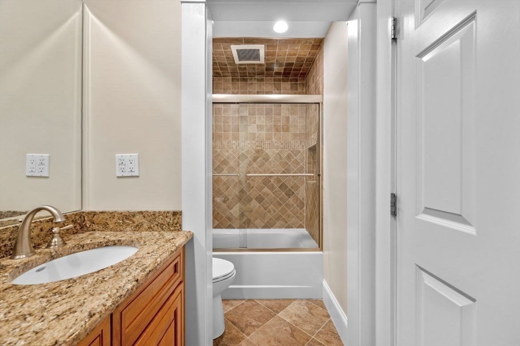 49 Columbia Road Arlington, MA 02474 - Photo 34 of 42 a bathroom with a granite countertop bathtub shower sink and mirror