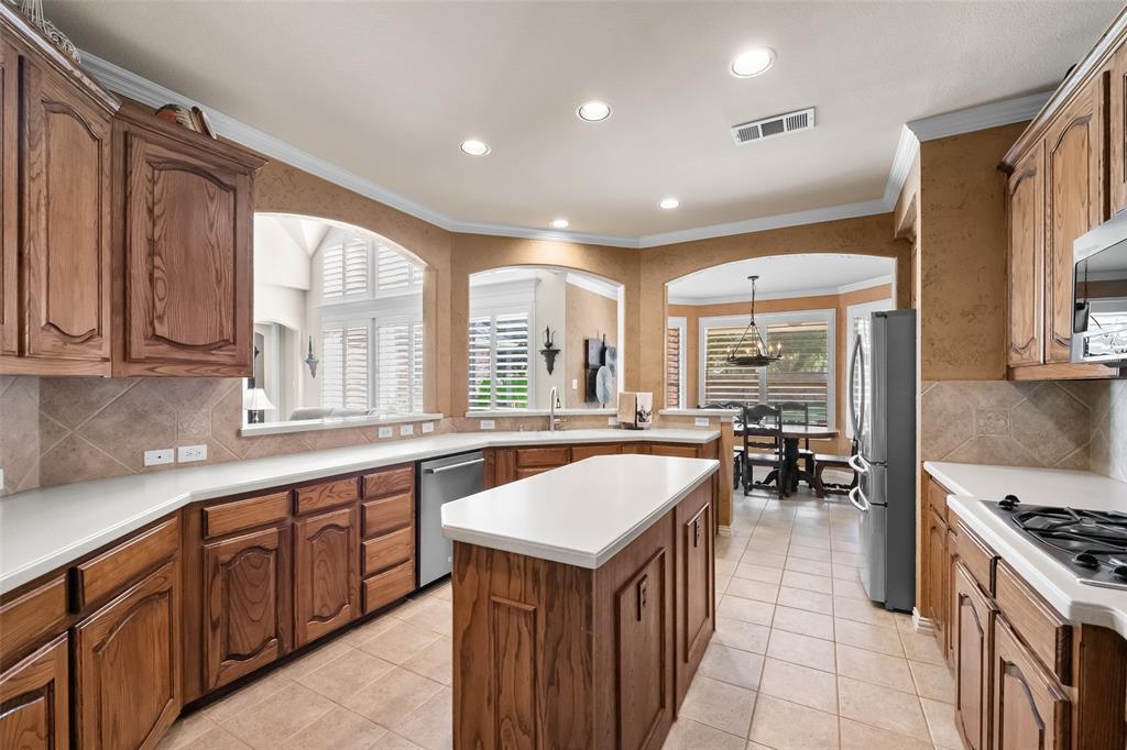 3904 Edna Valley Court Flower Mound, TX 75022 - Photo 13 of 36 a kitchen with a stove a sink a oven a dining table and chairs