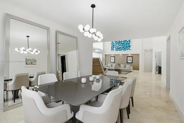 a dining room with furniture a chandelier and wooden floor