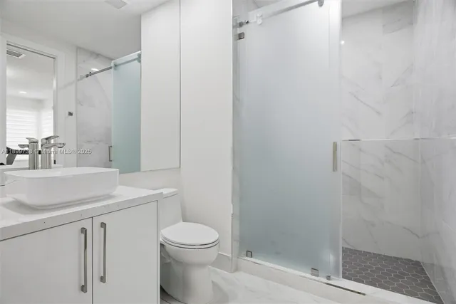 an aerial view of residential houses with outdoor space and trees