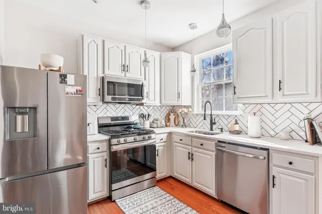 a kitchen with stainless steel appliances a stove sink and refrigerator