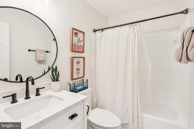 a bathroom with a sink a toilet and shower curtain