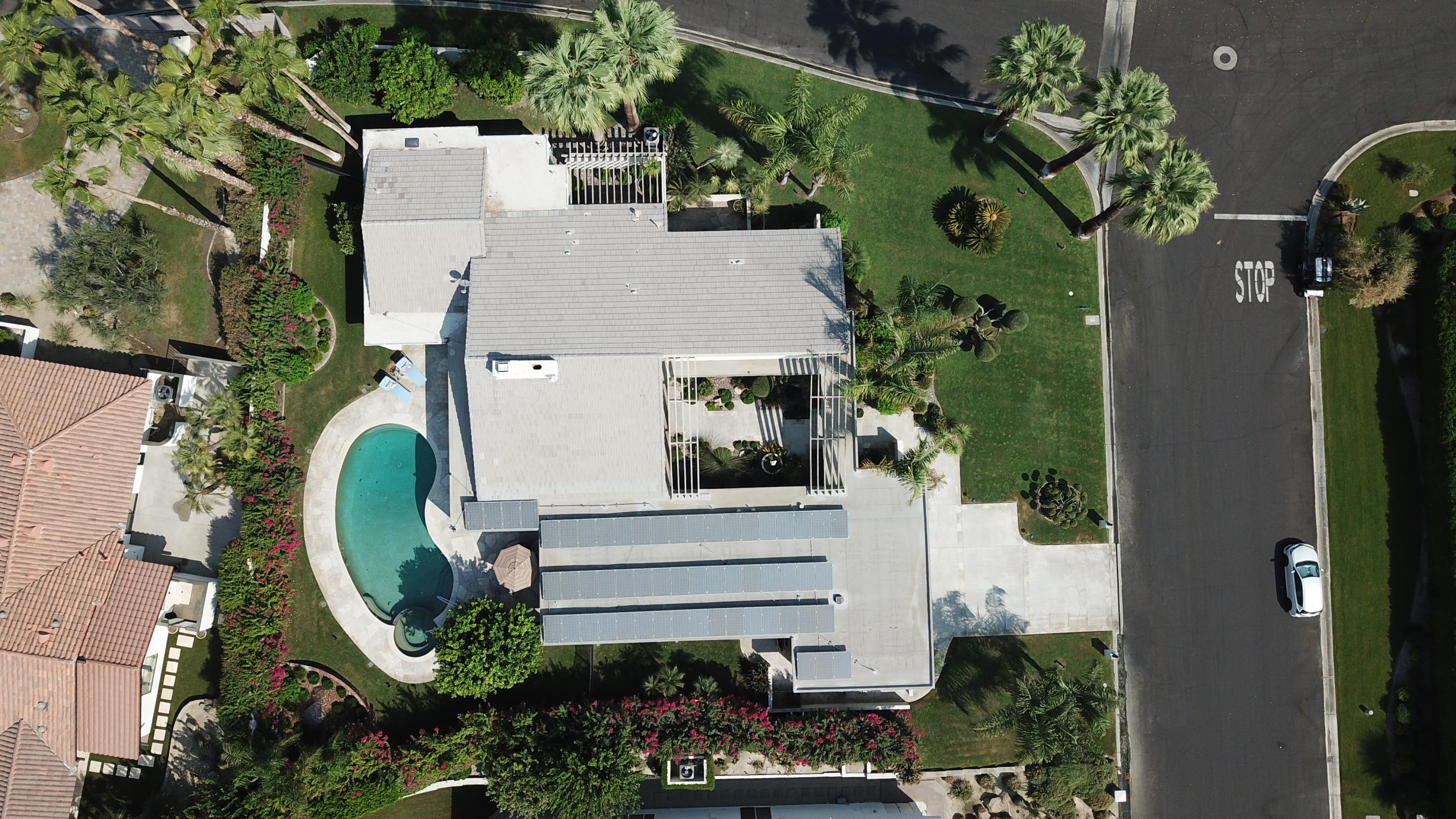 an aerial view of a house with garden space ocean and trees