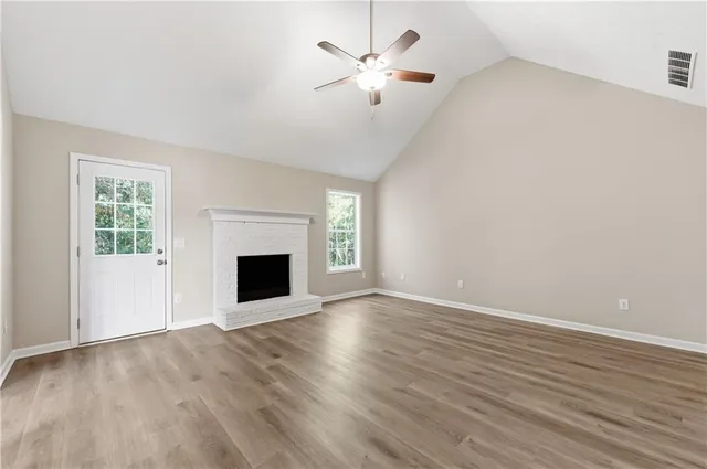 a view of an empty room with a fireplace and a window