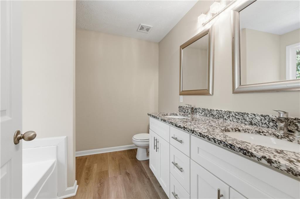 1730 Alcovy River Drive Dacula, GA 30019 - Photo 19 of 30 a bathroom with a granite countertop sink mirror vanity and toilet