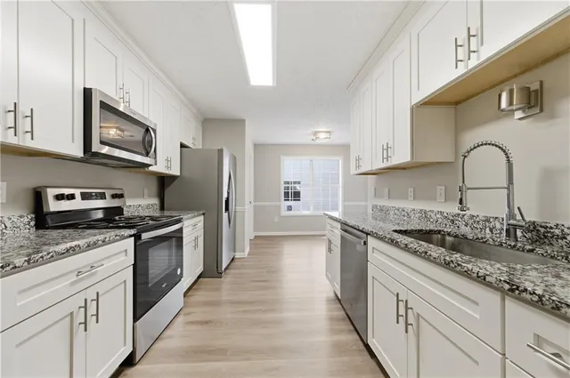 a large kitchen with stainless steel appliances granite countertop a stove and a sink