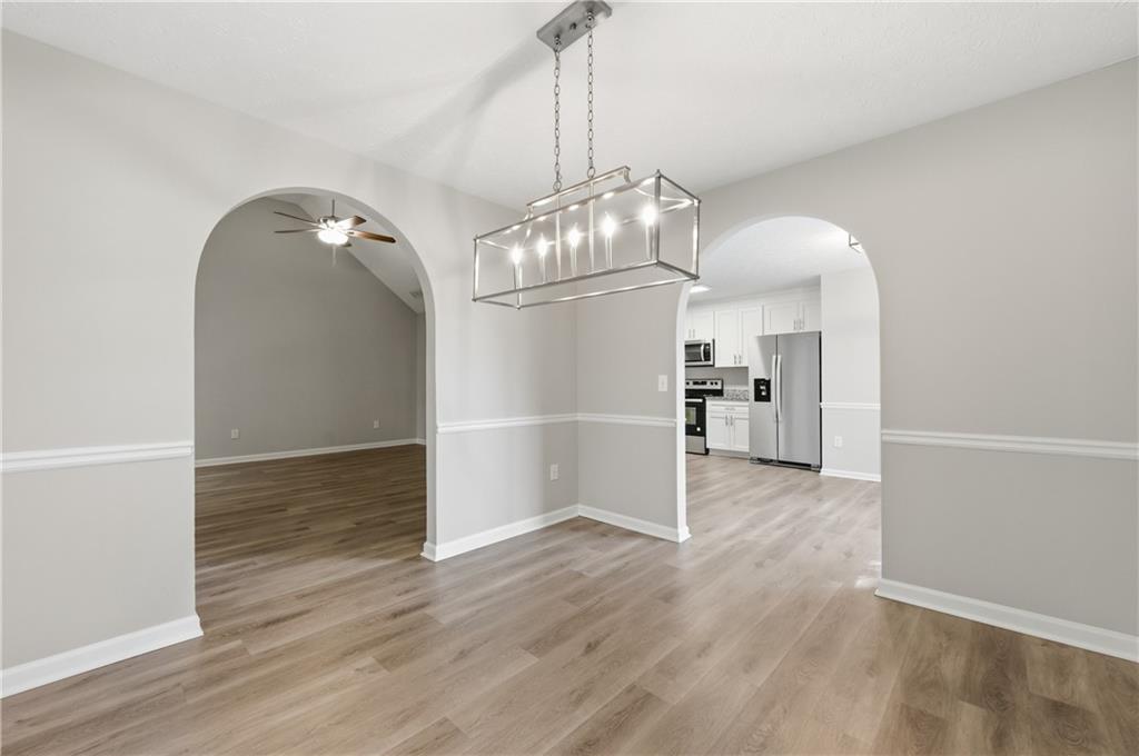 1730 Alcovy River Drive Dacula, GA 30019 - Photo 10 of 30 an empty room with wooden floor mirror and windows