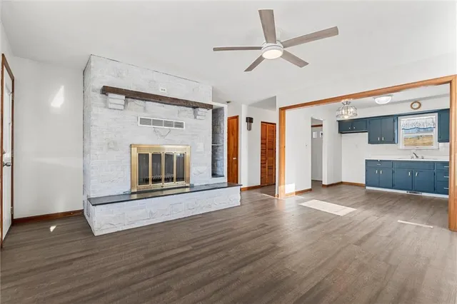 a view of an empty room with a fireplace and a window