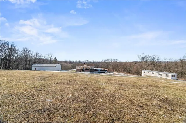 a view of a house with a yard and wooden fence