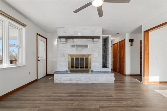 a view of an empty room with a fireplace and a window
