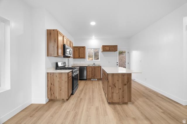 1563 South Deerbrook Road, Unit 267CHM Santaquin, UT 84655 - Photo 8 of 13 Contemporary kitchen featuring wood-finish cabinetry, light-toned countertops, and stainless steel appliances