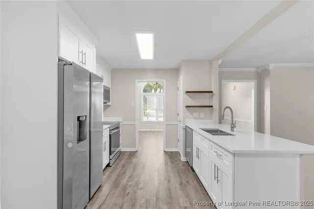 a kitchen with a white cabinets and chandelier