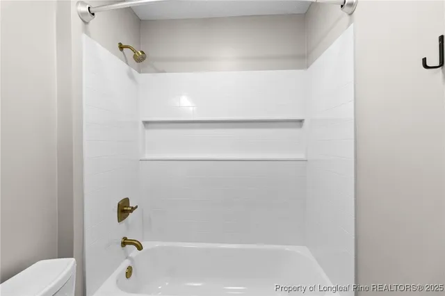 a bathroom with a granite countertop toilet a sink and a mirror