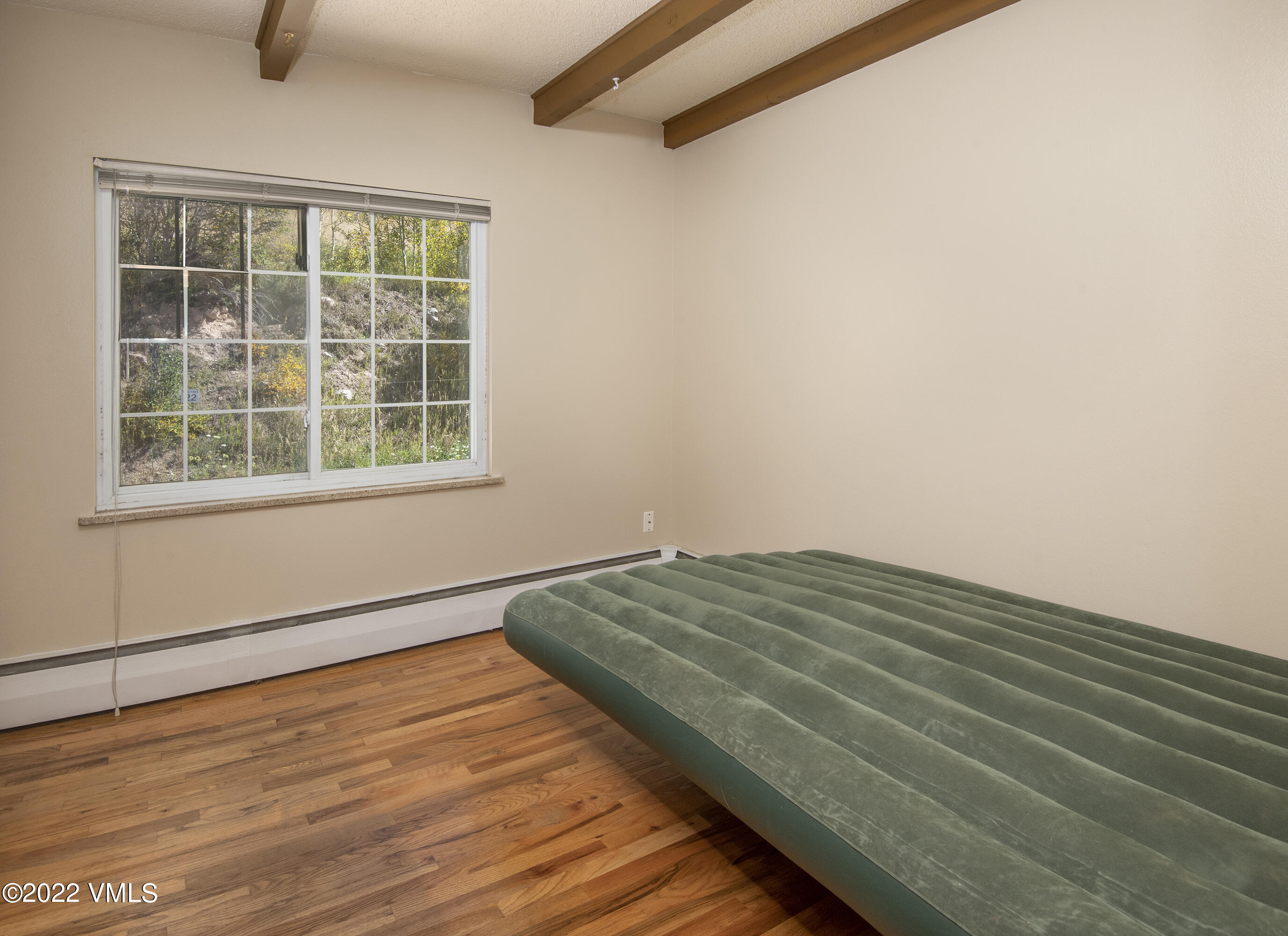 4073 Spruce Way, Unit 22 Vail, CO 81657 - Photo 14 of 25 an empty room with wooden floor and window