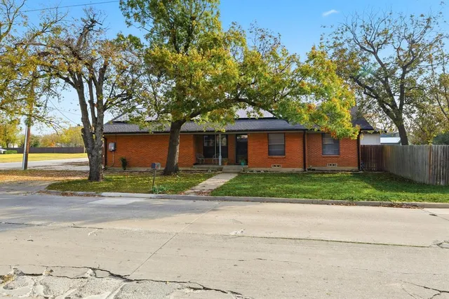 a front view of a house with a yard and trees