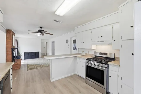 a kitchen with stainless steel appliances a stove sink and cabinets
