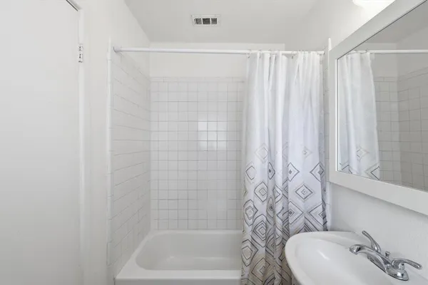 a bathroom with a shower curtain and a sink