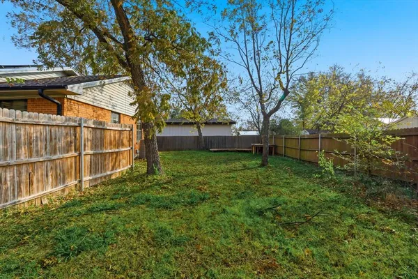 a view of backyard with wooden fence