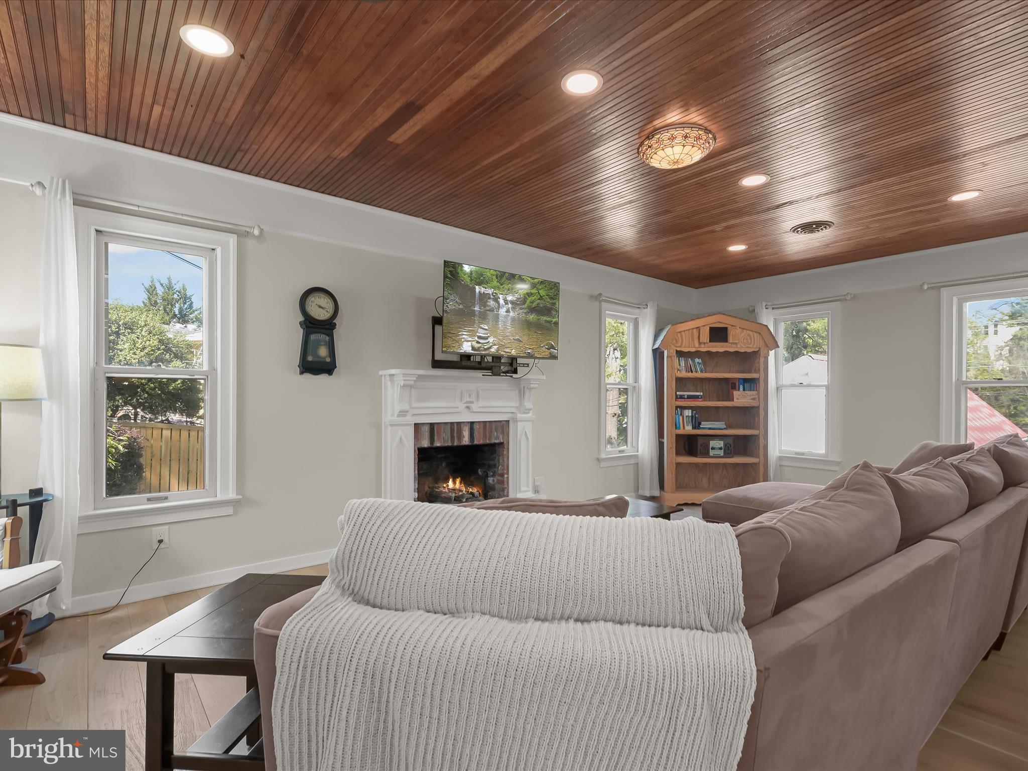 17712 Longdraft Road Gaithersburg, MD 20878 - Photo 26 of 85 a living room with furniture a fireplace and a flat screen tv