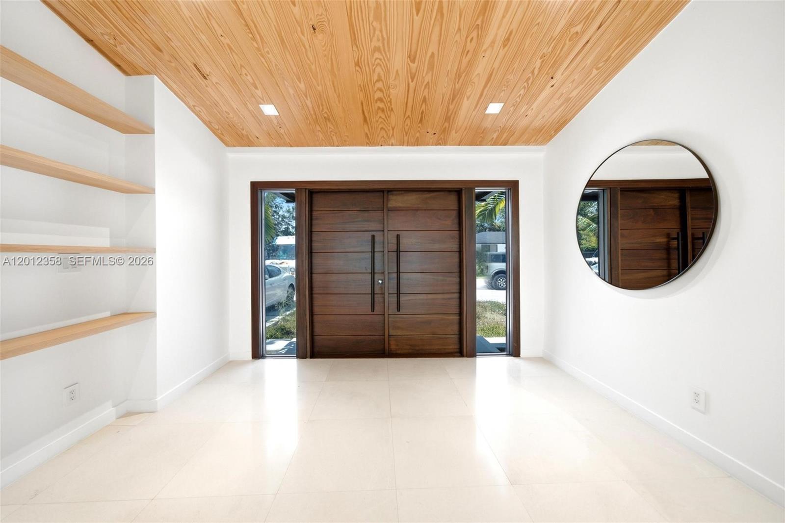 120 Northeast 49th Street Miami, FL 33137 - Photo 4 of 34 a view of a hallway with wooden floor and a large window