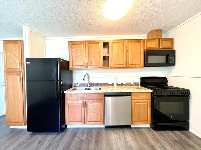a kitchen with stainless steel appliances granite countertop a refrigerator stove and sink