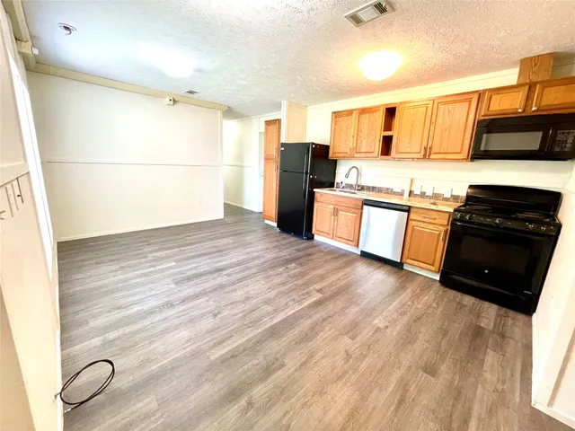 a kitchen with stainless steel appliances granite countertop a refrigerator and a stove top oven