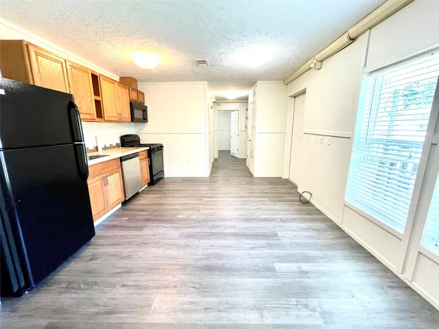 a view of kitchen with stainless steel appliances refrigerator stove microwave and cabinets