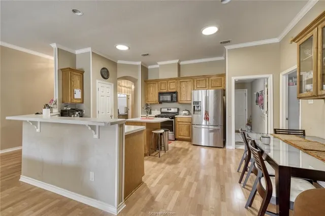 a kitchen with stainless steel appliances a refrigerator and a stove top oven
