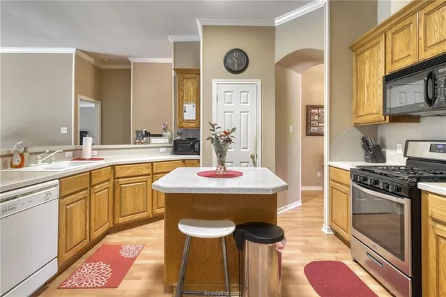 a kitchen with stainless steel appliances granite countertop a sink and a stove