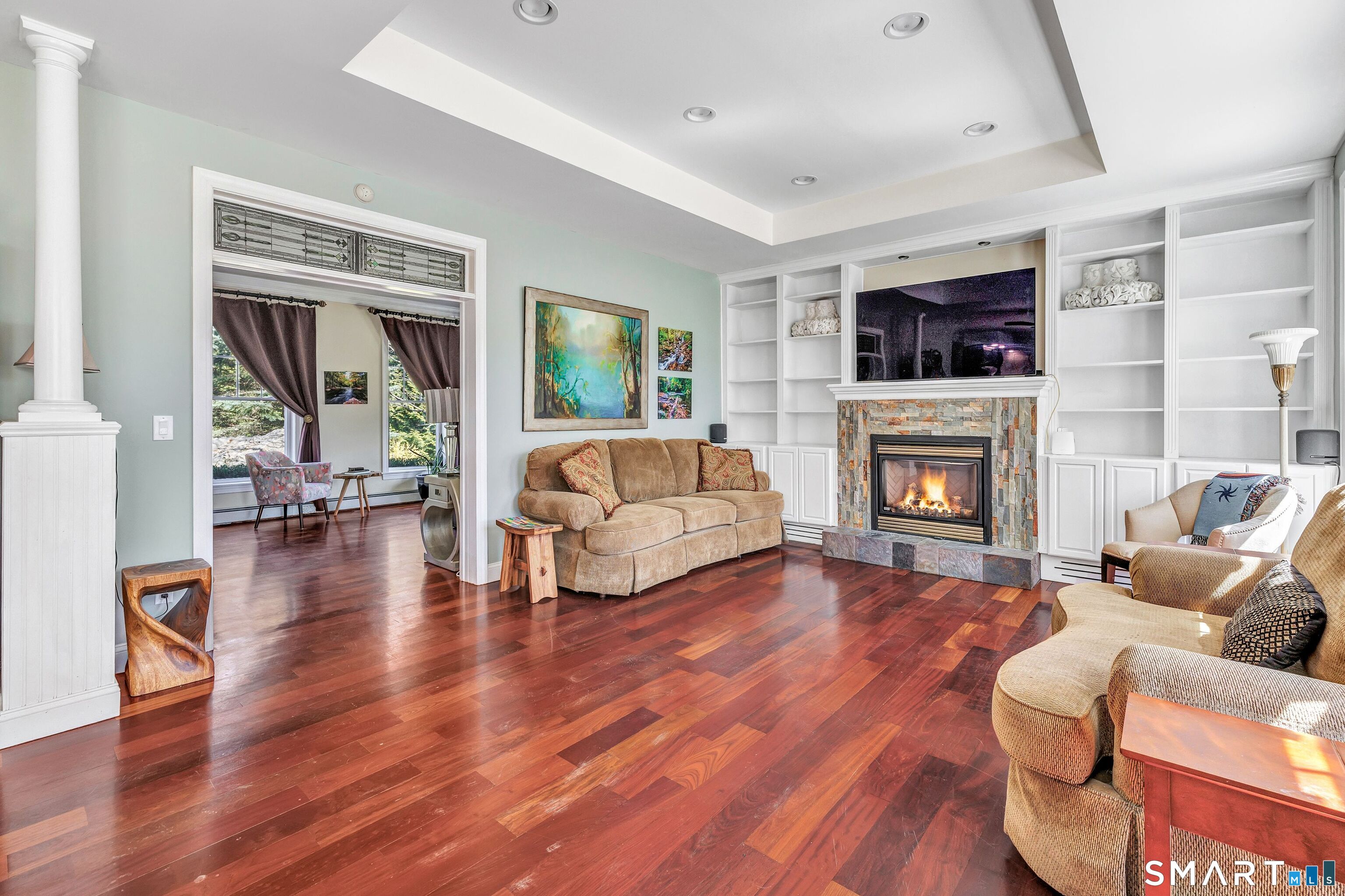 25 Starrs Ridge Road Redding, CT 06896 - Photo 13 of 38 Spacious family room centered around a gas fireplace with custom built-in's, creating an inviting space for relaxation and gatherings.