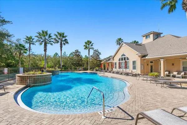 a view of a house with swimming pool and sitting area
