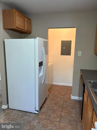 a view of a storage & utility room with a refrigerator