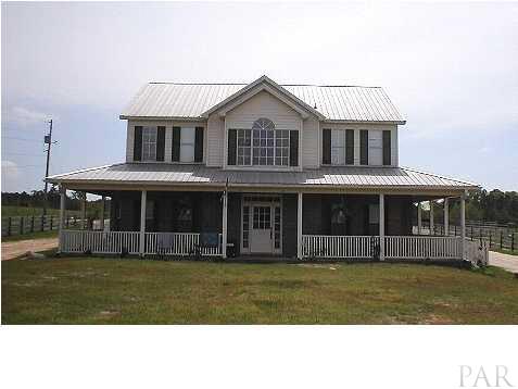 6959 Martin Road Milton, FL 32570 - Photo 1 of 11 a front view of a house with a garden
