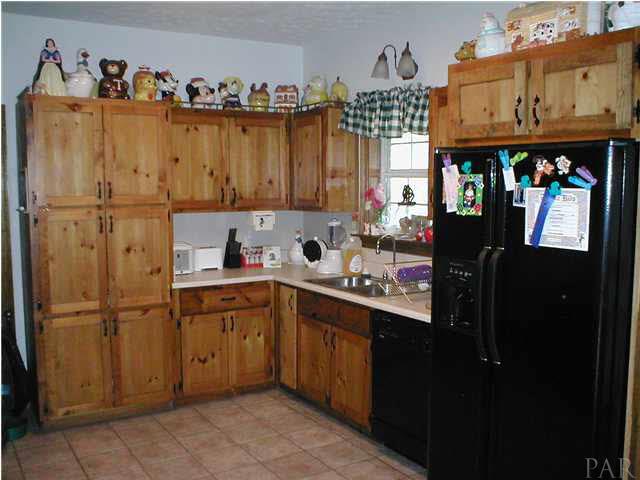 6959 Martin Road Milton, FL 32570 - Photo 3 of 11 a kitchen with a refrigerator and a sink