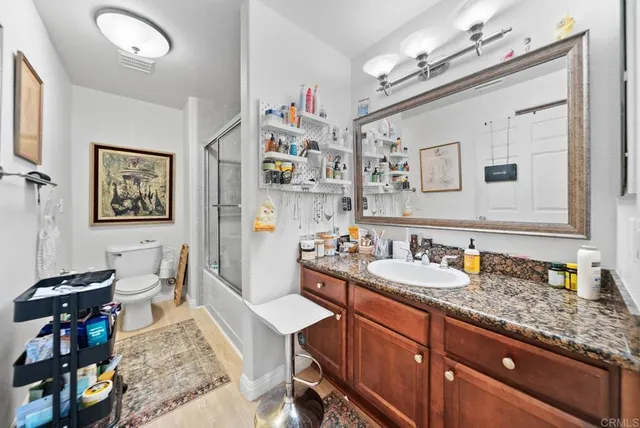 a spacious bathroom with a granite countertop sink a mirror and a shower