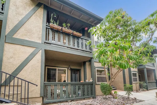 a front view of a house with a tree