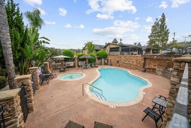 a view of a swimming pool with lawn chairs and a fire pit