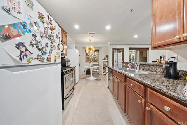 a kitchen with stainless steel appliances granite countertop a refrigerator and a sink