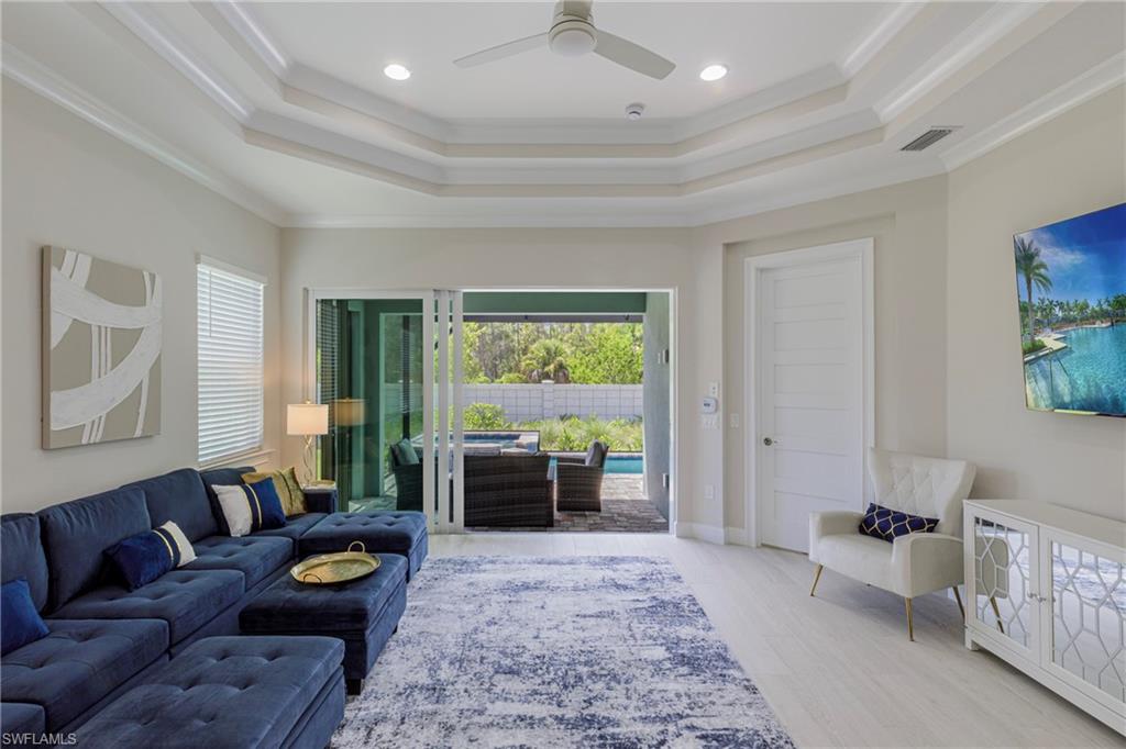 8909 Yucatan Court Naples, FL 34113 - Photo 3 of 36 Living room with plenty of natural light, crown molding, recessed lighting, a raised ceiling, and light wood-type flooring