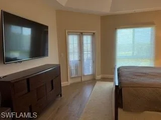 a living room with a flat screen tv a lamp and a window