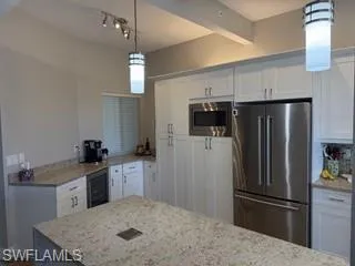 a kitchen with stainless steel appliances granite countertop a refrigerator a stove top oven a sink and dishwasher