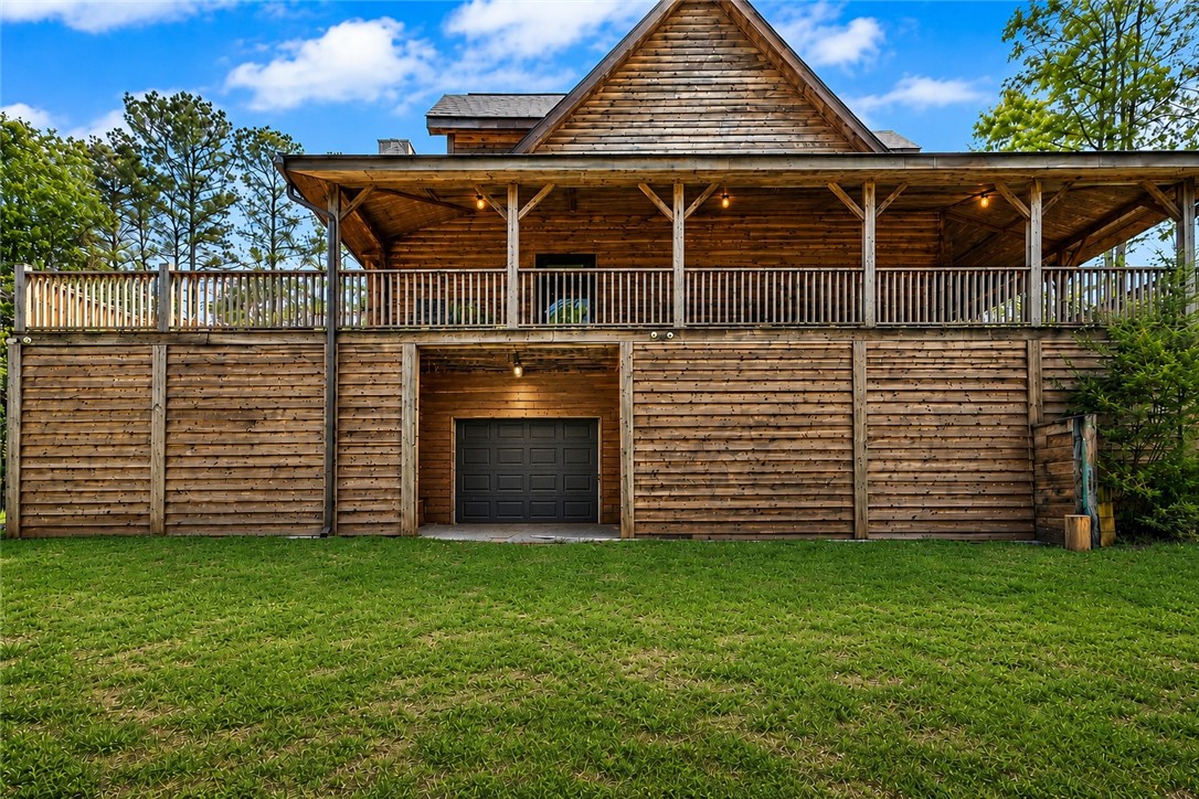 414 Devon Way Anderson, SC 29621 - Photo 34 of 50 A charming wood-clad residence offers a spacious balcony overlooking a manicured lawn, ideal for outdoor enjoyment.